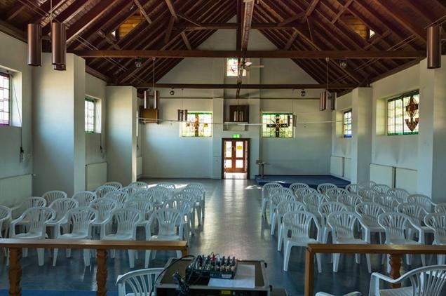 Die Chapel aus den 1930er Jahren wird dank der Förderung des Landes zu einem neuen Quartierstreff auf dem Hospital umgebaut. (Foto: Steffen Diemer) Blick in einen Kirchenraum mit offenem Holzdach und weißen Stühlen