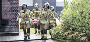 Ausbildung Leitern Vier Feuerwehrmänner tragen eine Leiter