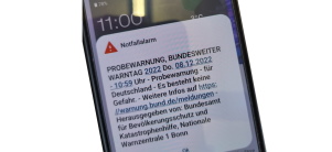 Symbolbild Cell Broadcast Nahaufnahme eines Handys das eine Notfallmeldung anzeigt.