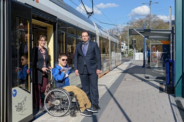 Mann mit Rollstuhl wird durch die Tür einer Straßenbahn geschoben (Foto: Rothe)