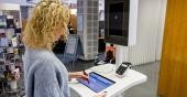 Eine Frau unterschreibt digital auf dem Bildschirm des neuen Selbstbedienungsterminal. (Foto: Stadt Heidelberg)