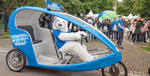 Eisbär-Maskottchen in Fahrradrikscha bei der ICCA 2019.