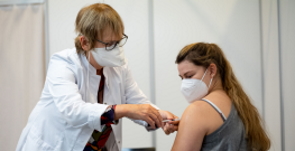 Eine Ärztin verabreicht einer jungen Frau eine Impfung